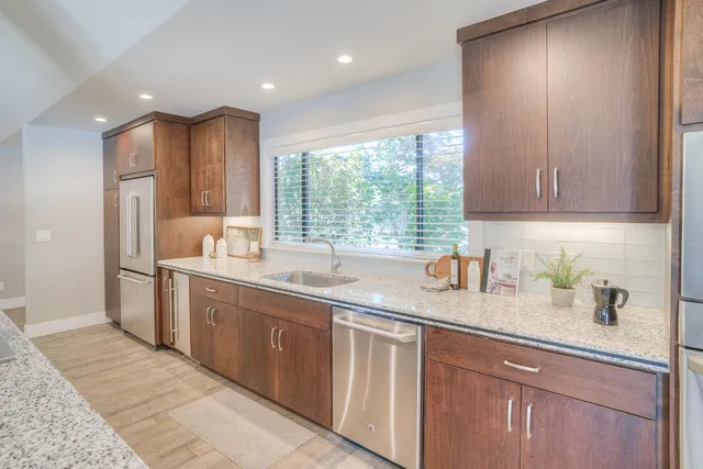 a dining room with furniture large windows and a chandelier