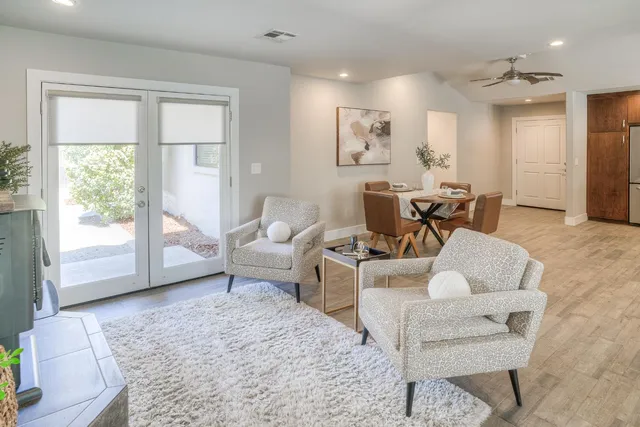 a kitchen with stainless steel appliances granite countertop a refrigerator a sink dishwasher a stove and a dining table with wooden floor