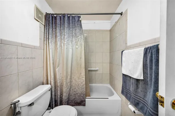 a bathroom with a toilet and a shower curtain