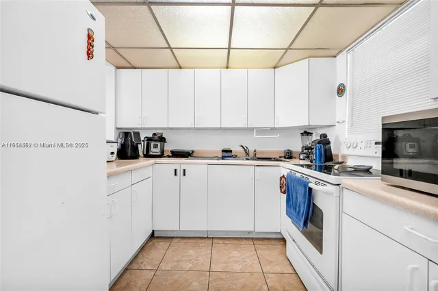 a kitchen with a white cabinets and white appliances