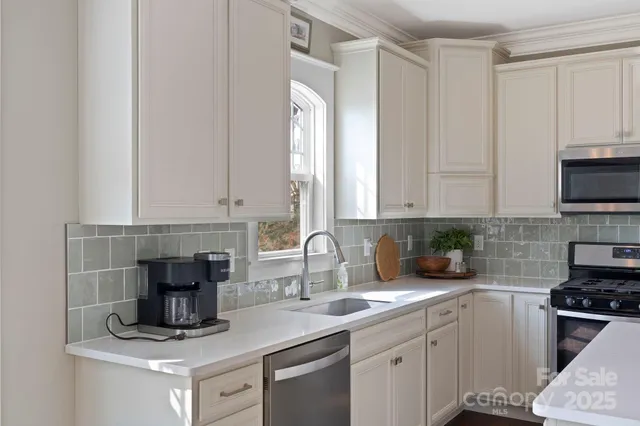 a kitchen with appliances a sink and cabinets