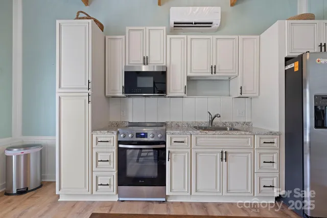 a kitchen with stainless steel appliances granite countertop a stove a refrigerator and a microwave