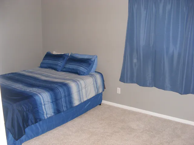 a bedroom with a bed and curtain