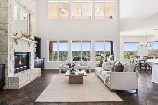 a living room with furniture large window and a fireplace
