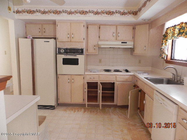 4146 Blueberry Hill Road Bushkill, PA 18324 - Photo 4 of 14 a kitchen with white cabinets and white appliances