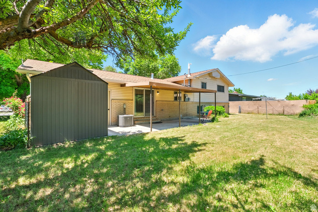 1188 600 East Logan, UT 84341 - Photo 16 of 16 Back of property featuring brick siding, a patio, board and batten siding, and a storage shed
