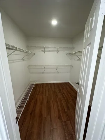 an empty room with a ceiling fan and hardwood