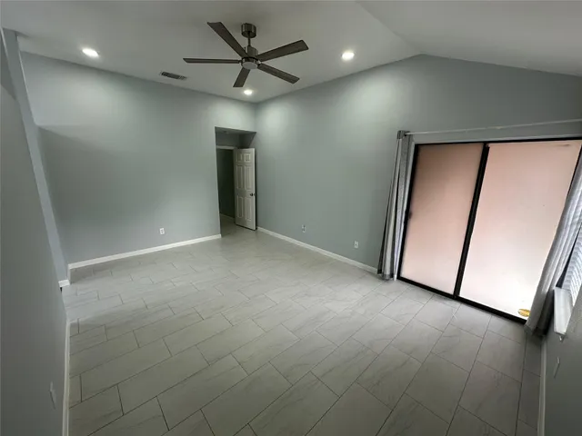 an empty room with windows and fan