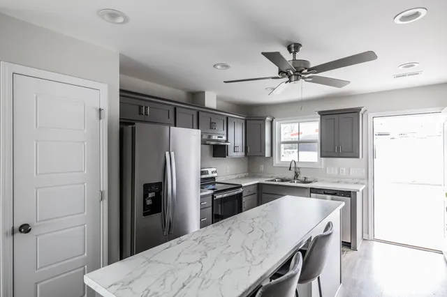 a kitchen with granite countertop a refrigerator and a sink