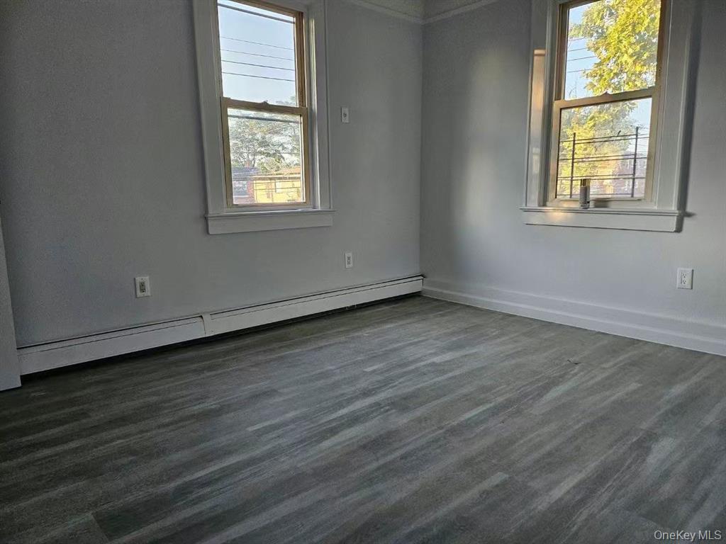 144-18 Negundo Avenue Queens, NY 11355 - Photo 3 of 7 an empty room with wooden floor and windows
