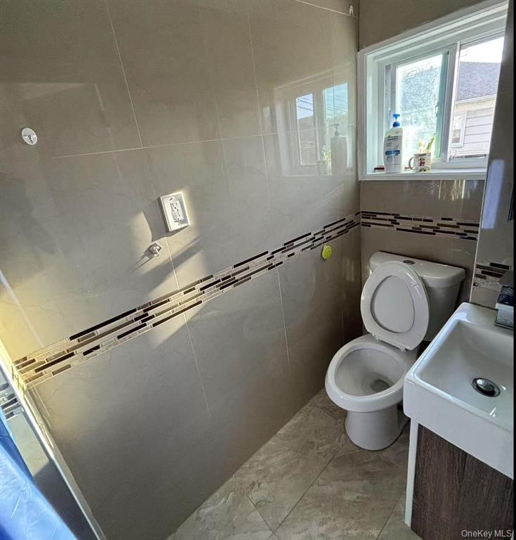 144-18 Negundo Avenue Queens, NY 11355 - Photo 7 of 7 a bathroom with a granite countertop sink toilet and a mirror