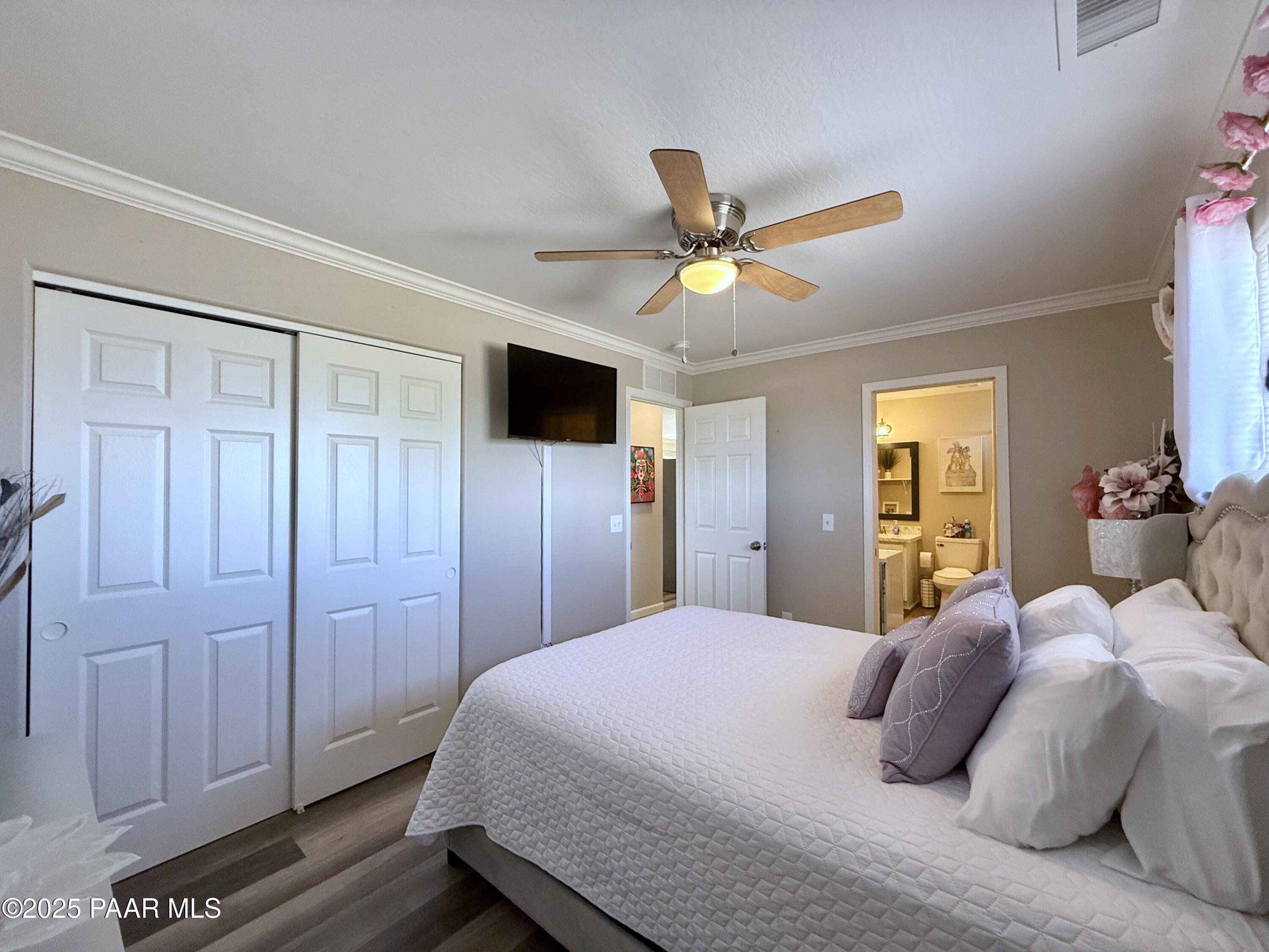20233 East Sunset Lane Mayer, AZ 86333 - Photo 26 of 42 a bedroom with a large bed a ceiling fan and a dresser