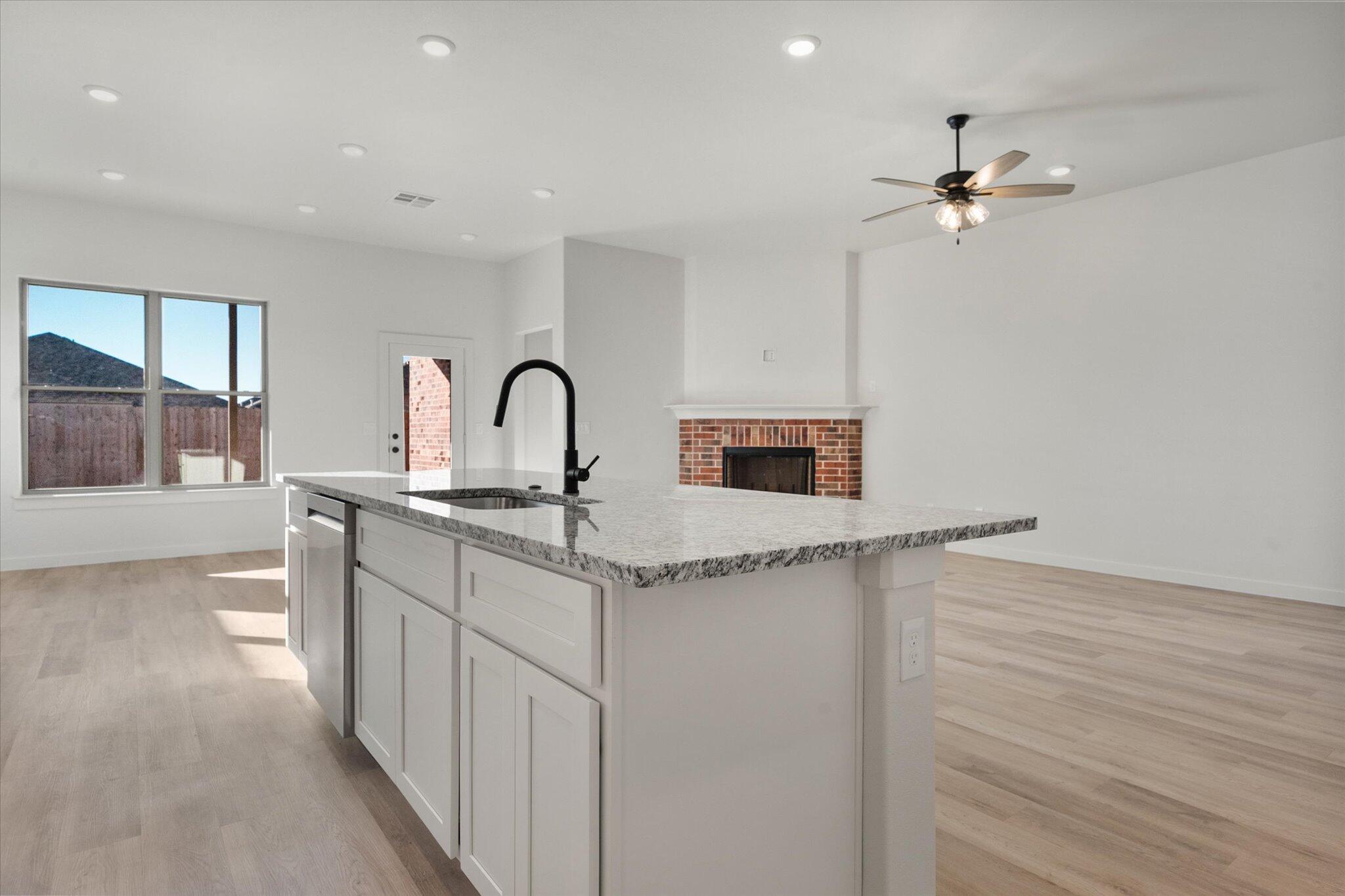 709 East 30th Street Wolfforth, TX 79382 - Photo 12 of 25 a kitchen with stainless steel appliances granite countertop a sink a stove top oven and cabinets