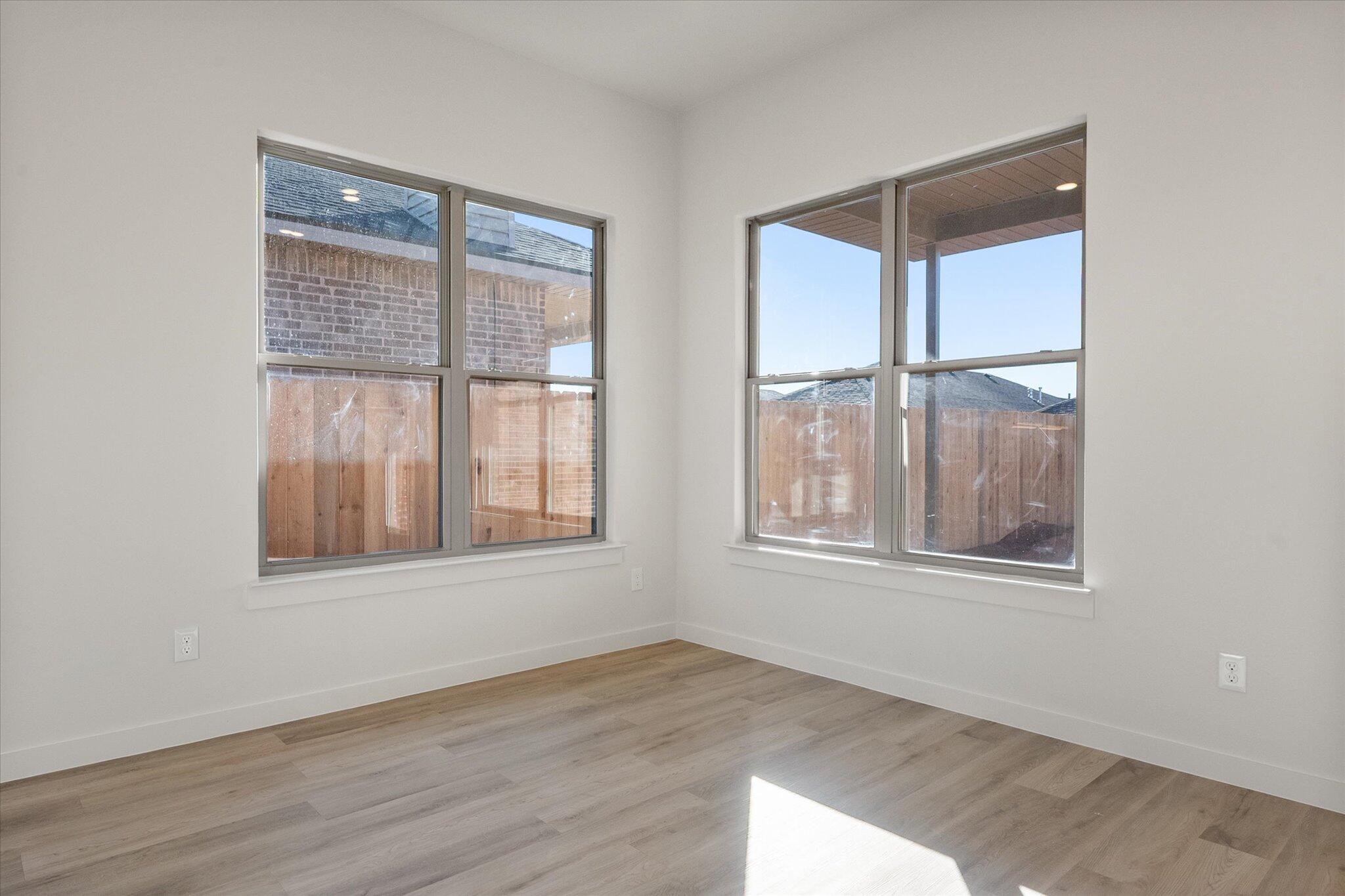 709 East 30th Street Wolfforth, TX 79382 - Photo 13 of 25 an empty room with wooden floor and windows