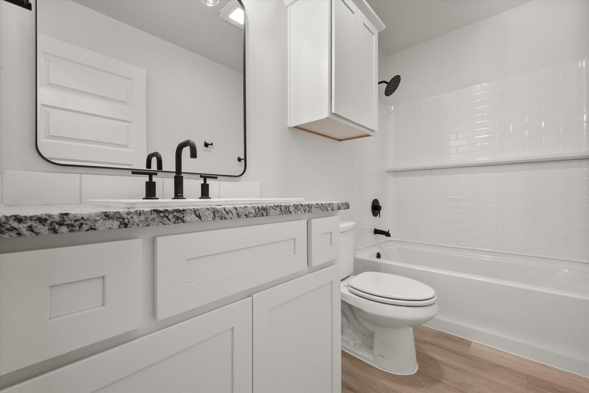 709 East 30th Street Wolfforth, TX 79382 - Photo 19 of 25 a bathroom with a sink toilet vanity and tub