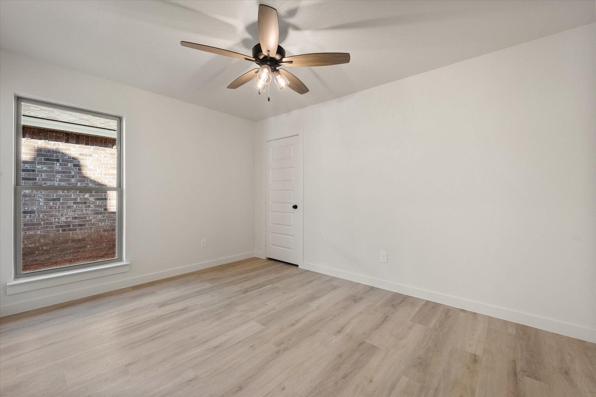 709 East 30th Street Wolfforth, TX 79382 - Photo 21 of 25 an empty room with a window and a fan