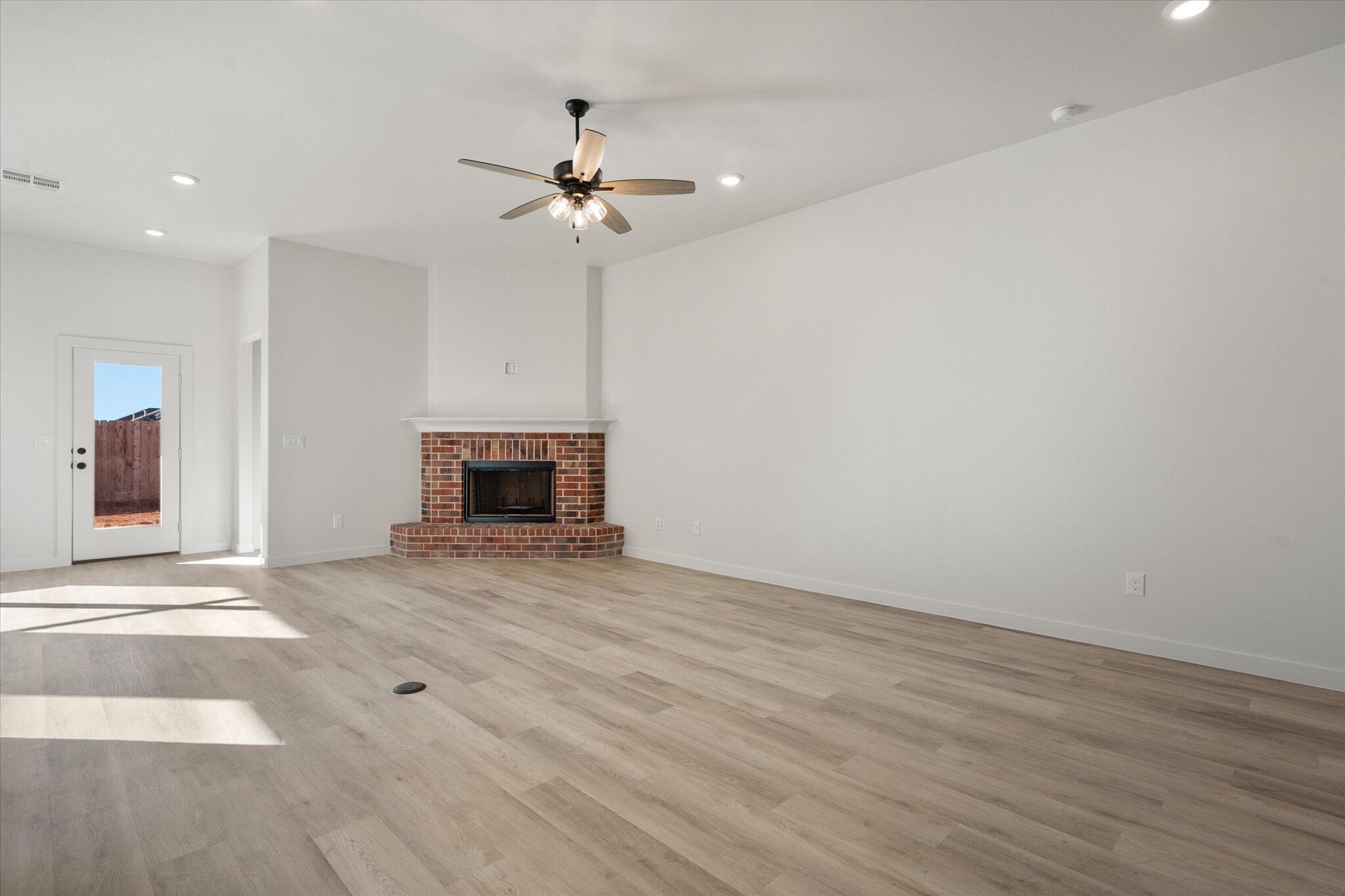 709 East 30th Street Wolfforth, TX 79382 - Photo 4 of 25 a view of empty room with wooden floor and fan