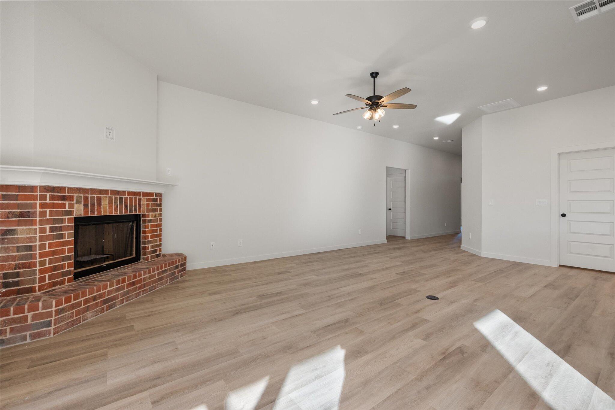 709 East 30th Street Wolfforth, TX 79382 - Photo 5 of 25 an empty room with fan and fireplace