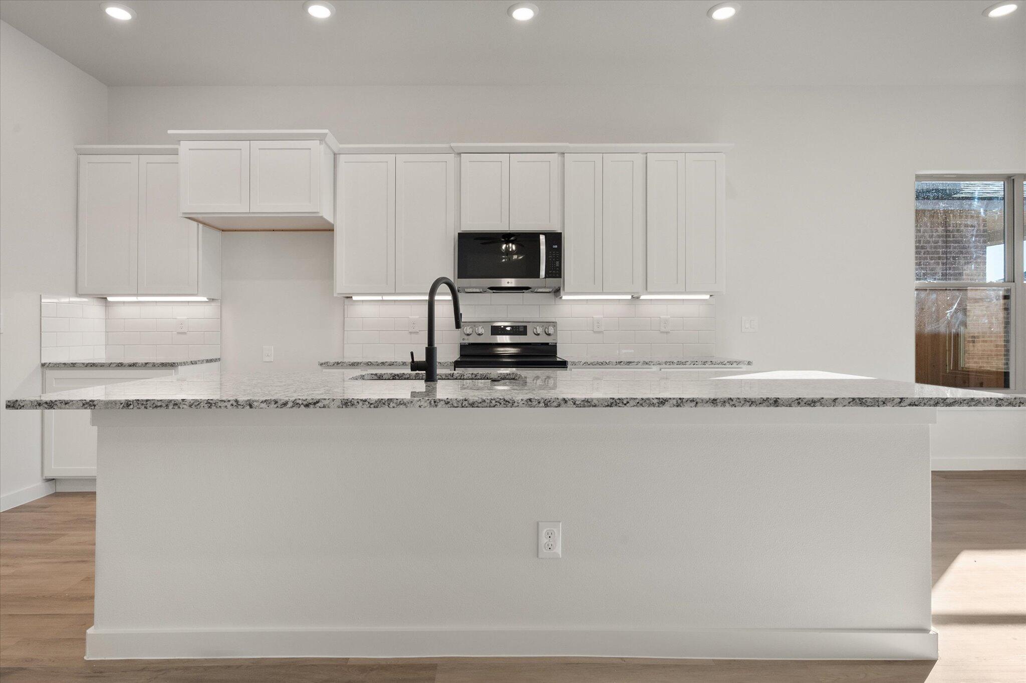 709 East 30th Street Wolfforth, TX 79382 - Photo 8 of 25 a kitchen with a sink a stove and cabinets