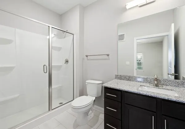 a bathroom with a granite countertop sink toilet and shower