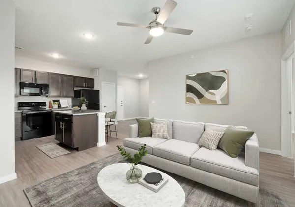 a living room with furniture kitchen and a chandelier