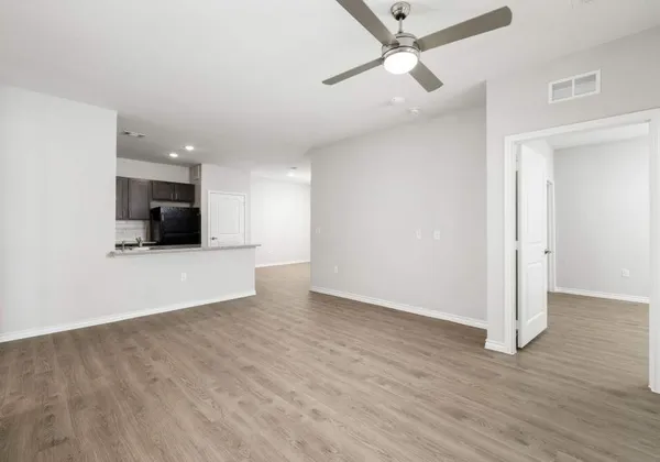 a view of a livingroom with wooden floor and a ceiling fan