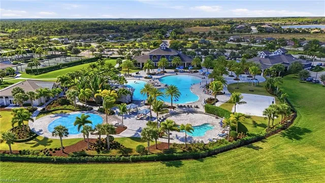 an aerial view of ocean and residential houses with outdoor space