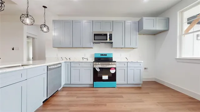 a kitchen with stainless steel appliances granite countertop a refrigerator and a stove top oven