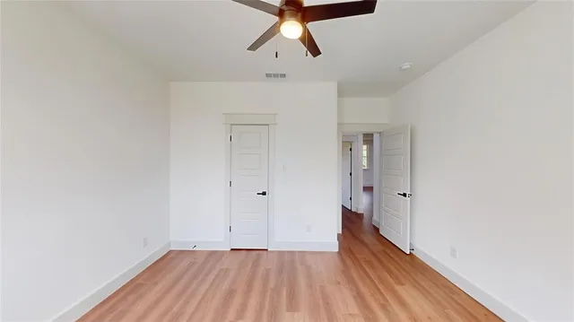 a view of a room with wooden floor and ceiling fan