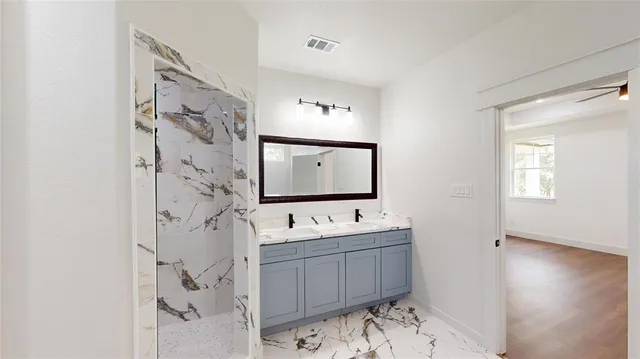 a bathroom with a sink mirror and a shower