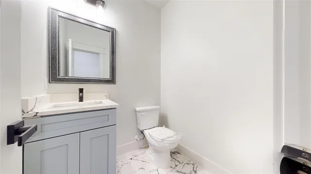 a bathroom with a toilet a sink and mirror