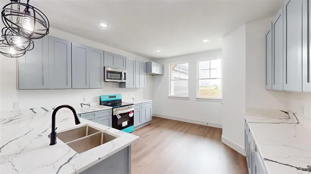 a kitchen with stainless steel appliances a sink a stove and cabinets