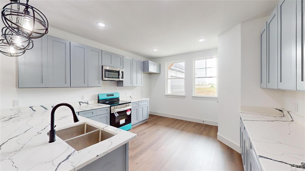 416 Linden Street Keene, TX 76059 - Photo 8 of 33 a kitchen with stainless steel appliances a sink a stove and cabinets