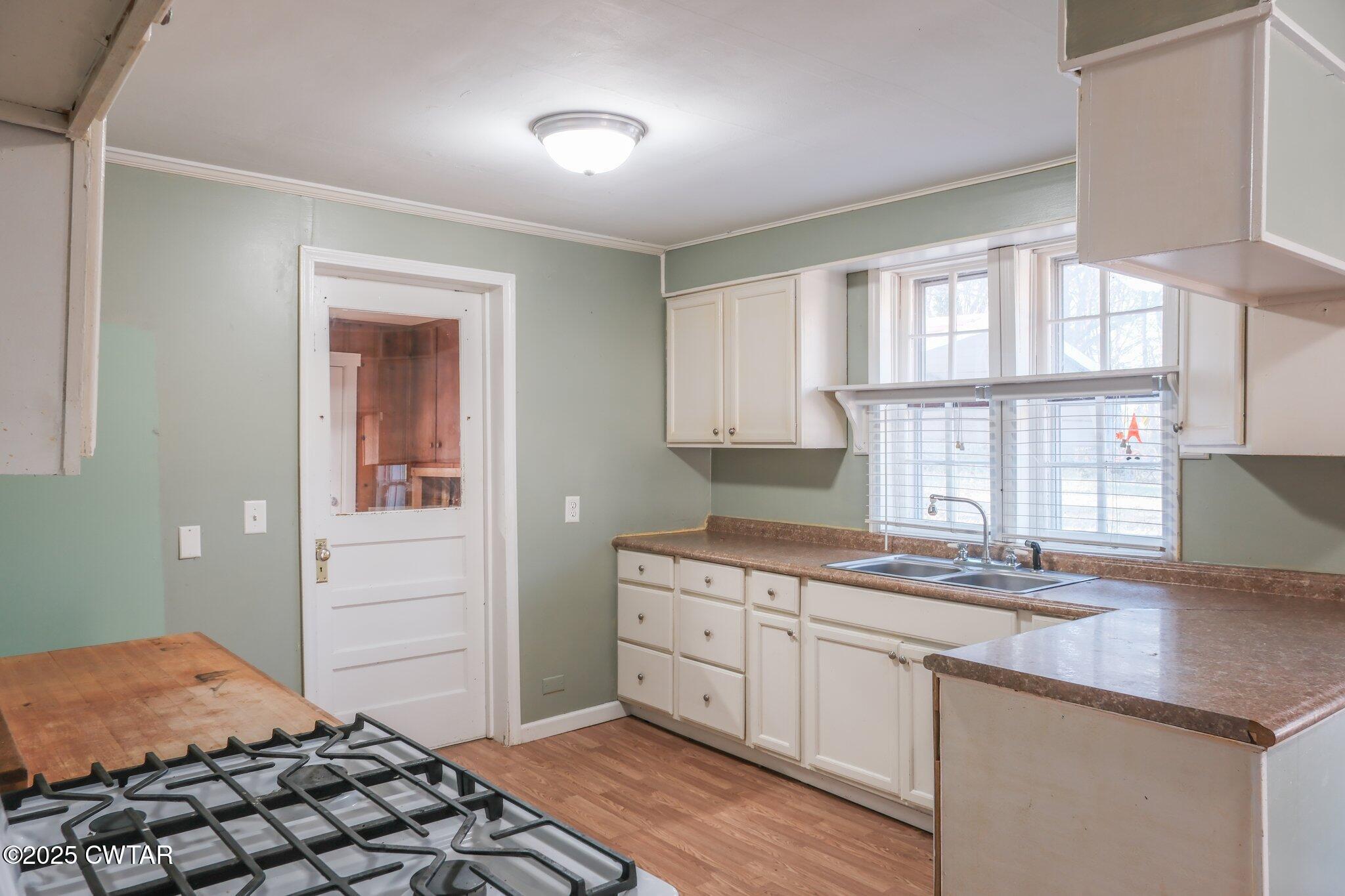 305 Phelps Street Gleason, TN 38229 - Photo 8 of 28 a kitchen with a sink stove and cabinets