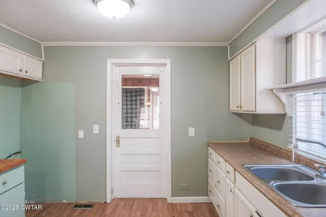 a kitchen with a sink cabinets and a window