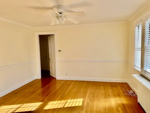 a view of a room with wooden floor and white walls
