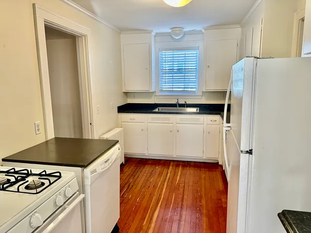 a kitchen with granite countertop a refrigerator and a stove