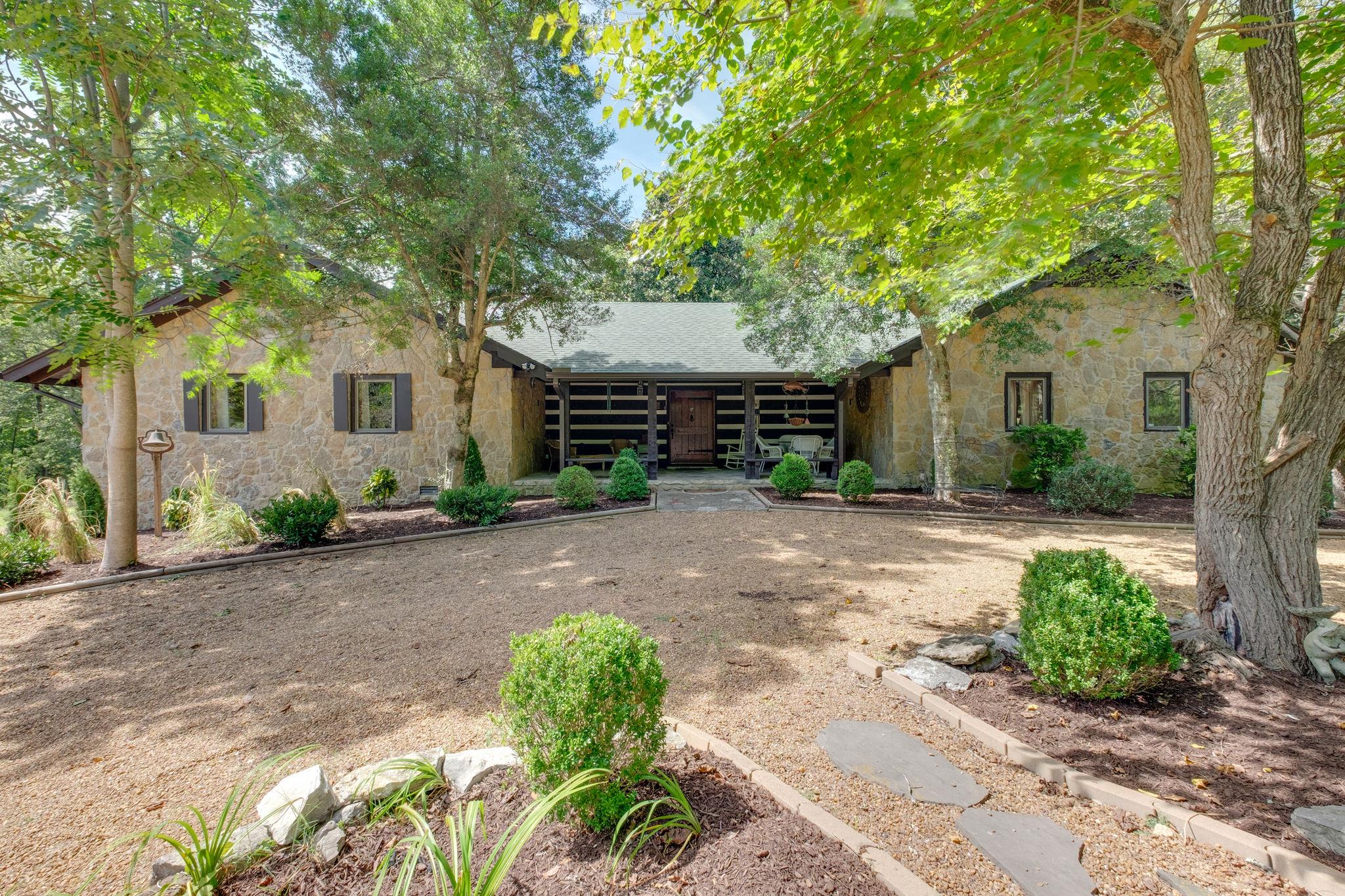 a front view of a house with a yard and a garden