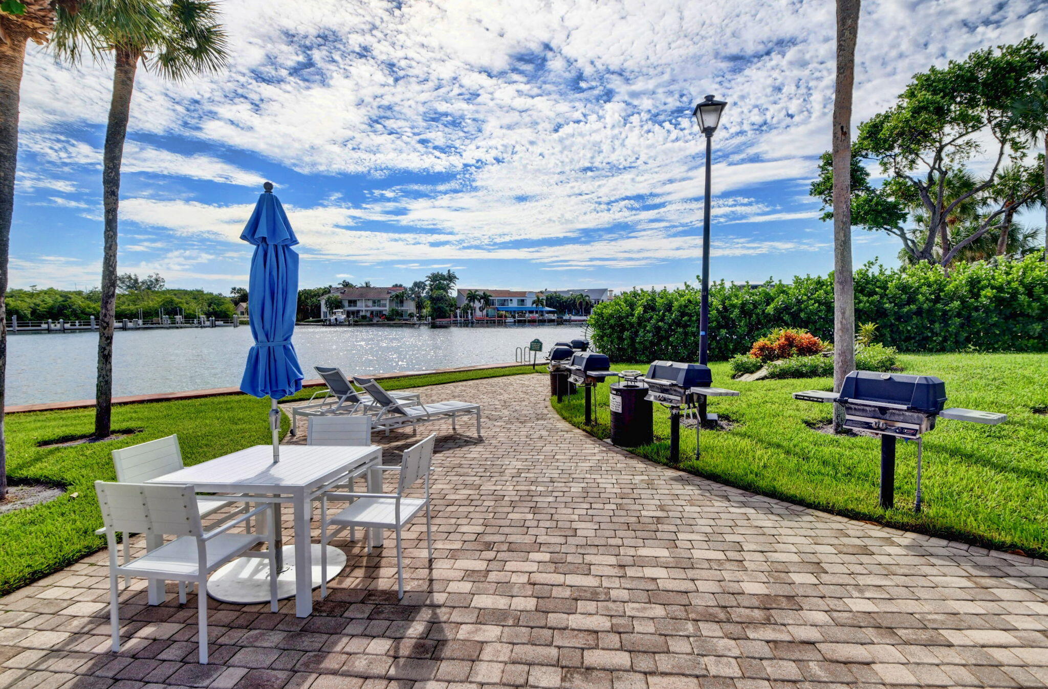 859 Jeffery Street, Unit 7030 Boca Raton, FL 33487 - Photo 32 of 53 a view of a patio with chairs potted plants and a palm tree