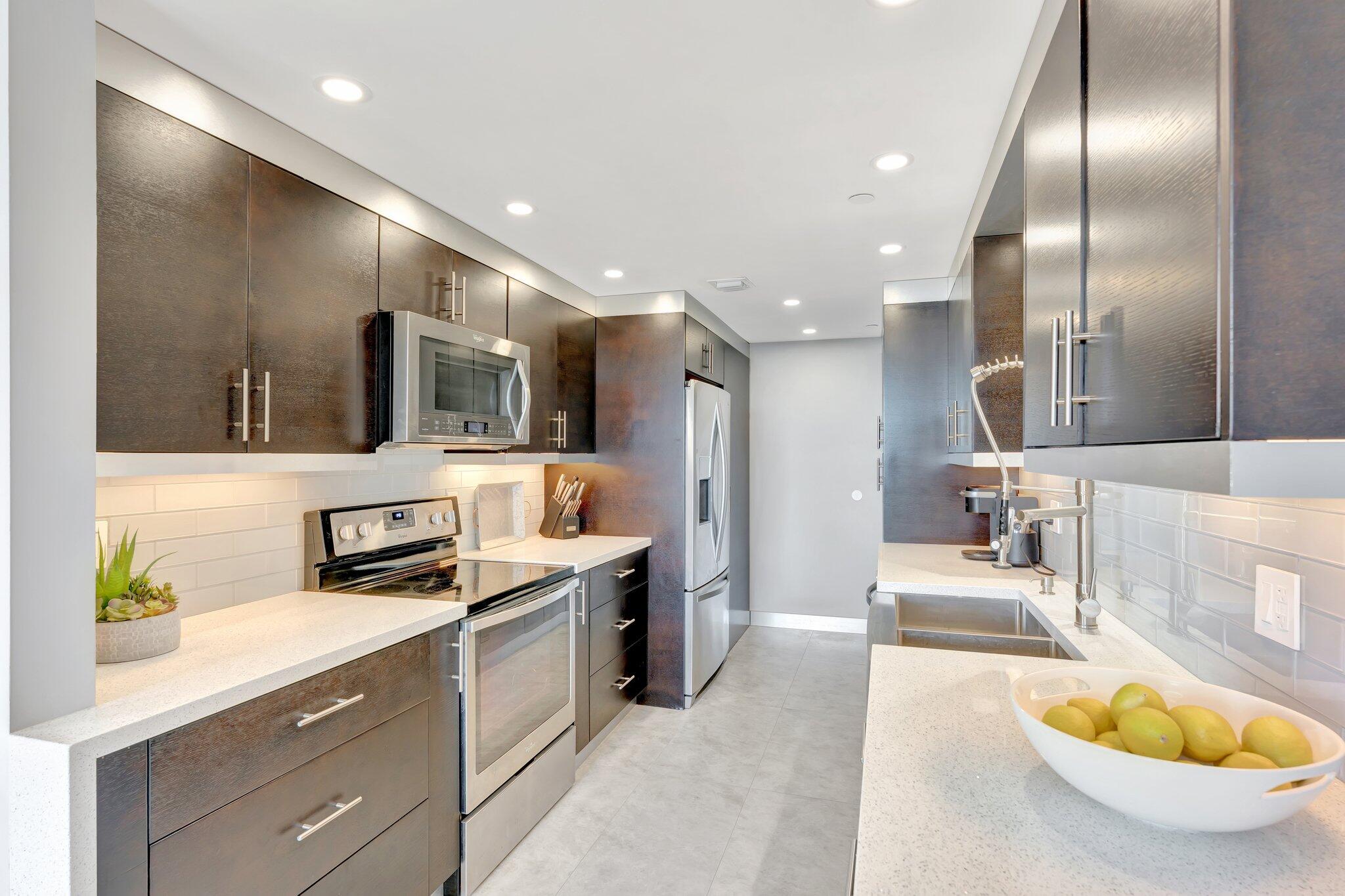 859 Jeffery Street, Unit 7030 Boca Raton, FL 33487 - Photo 5 of 53 a large kitchen with stainless steel appliances kitchen island granite countertop a sink and cabinets