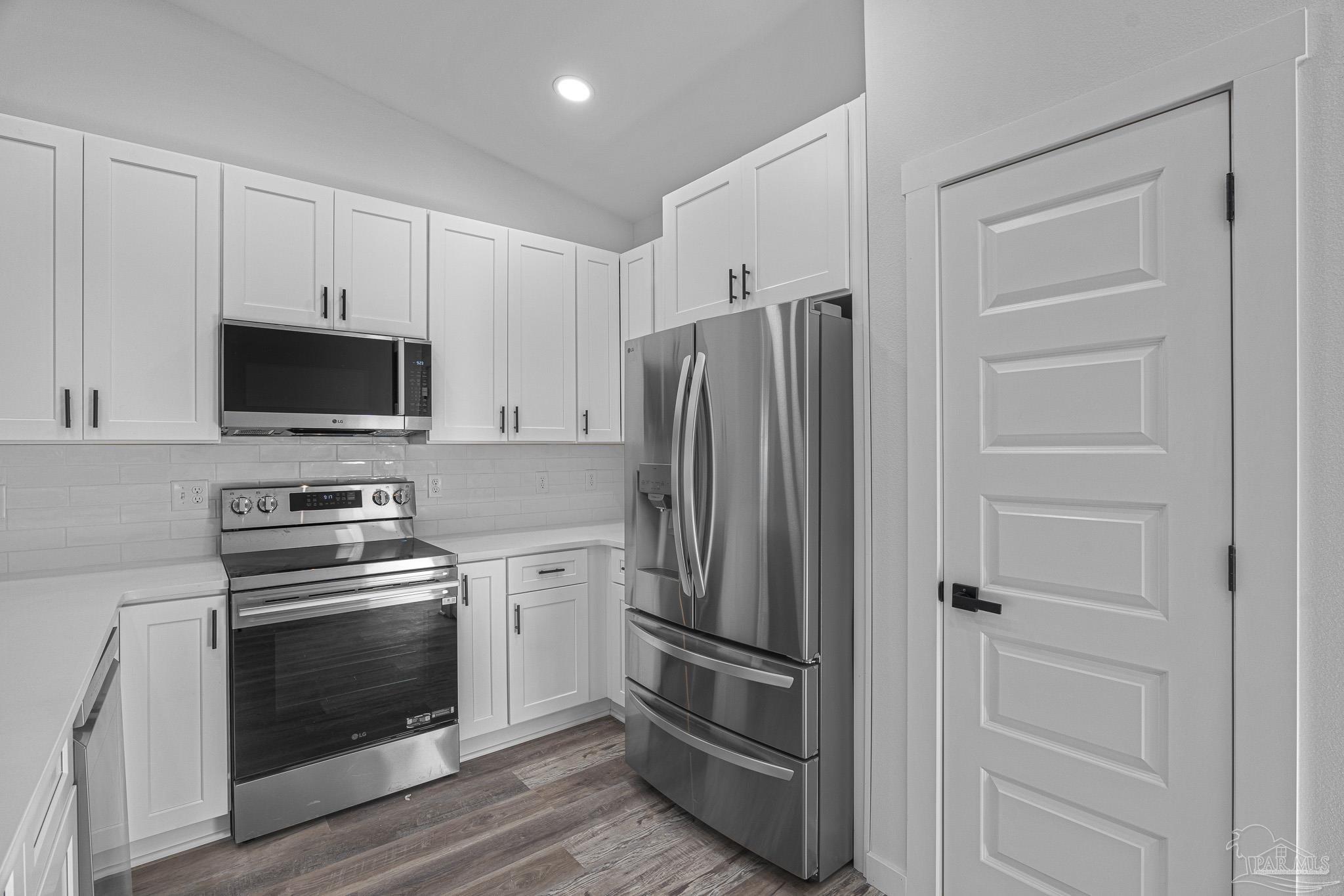 5005 Saufley Field Road Pensacola, FL 32526 - Photo 22 of 27 a kitchen with cabinets stainless steel appliances and wooden floor