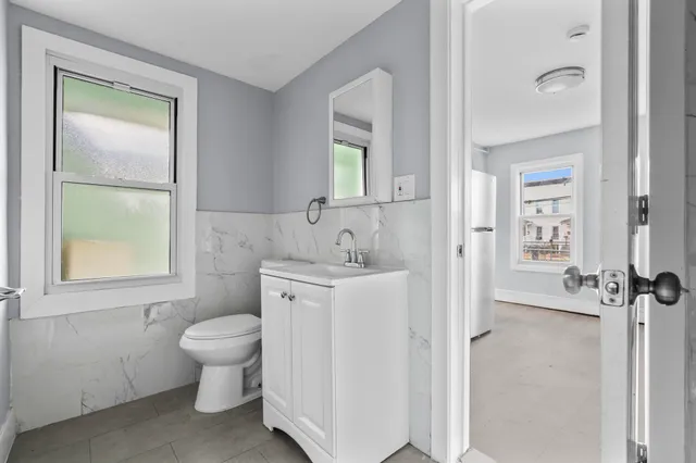 a spacious bathroom with a toilet sink and a mirror