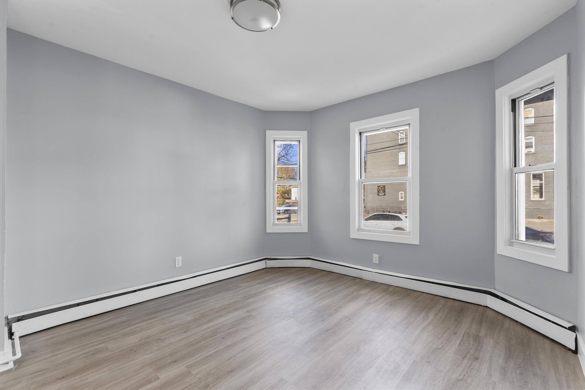 746 Maple Street Bridgeport, CT 06608 - Photo 19 of 38 an empty room with wooden floor and windows