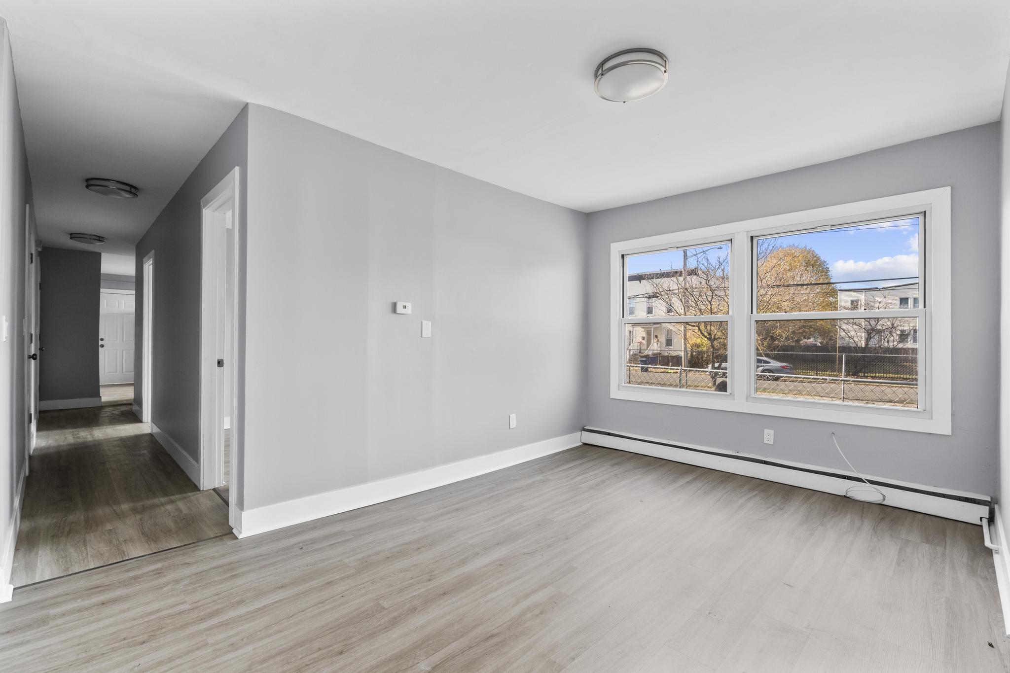 746 Maple Street Bridgeport, CT 06608 - Photo 21 of 38 a view of an empty room with a window and wooden floor