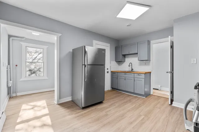 a kitchen with a refrigerator sink and cabinets