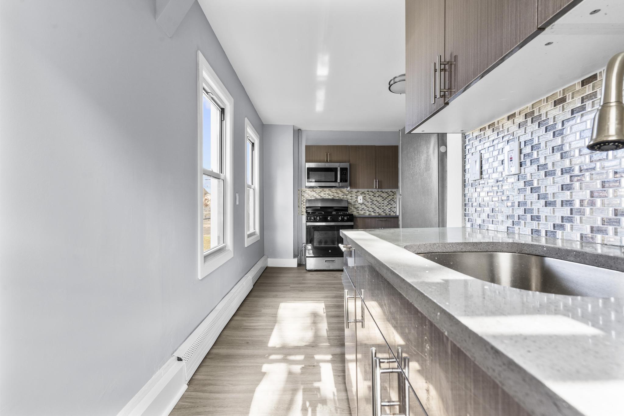 746 Maple Street Bridgeport, CT 06608 - Photo 10 of 38 a large kitchen with a large window and stainless steel appliances