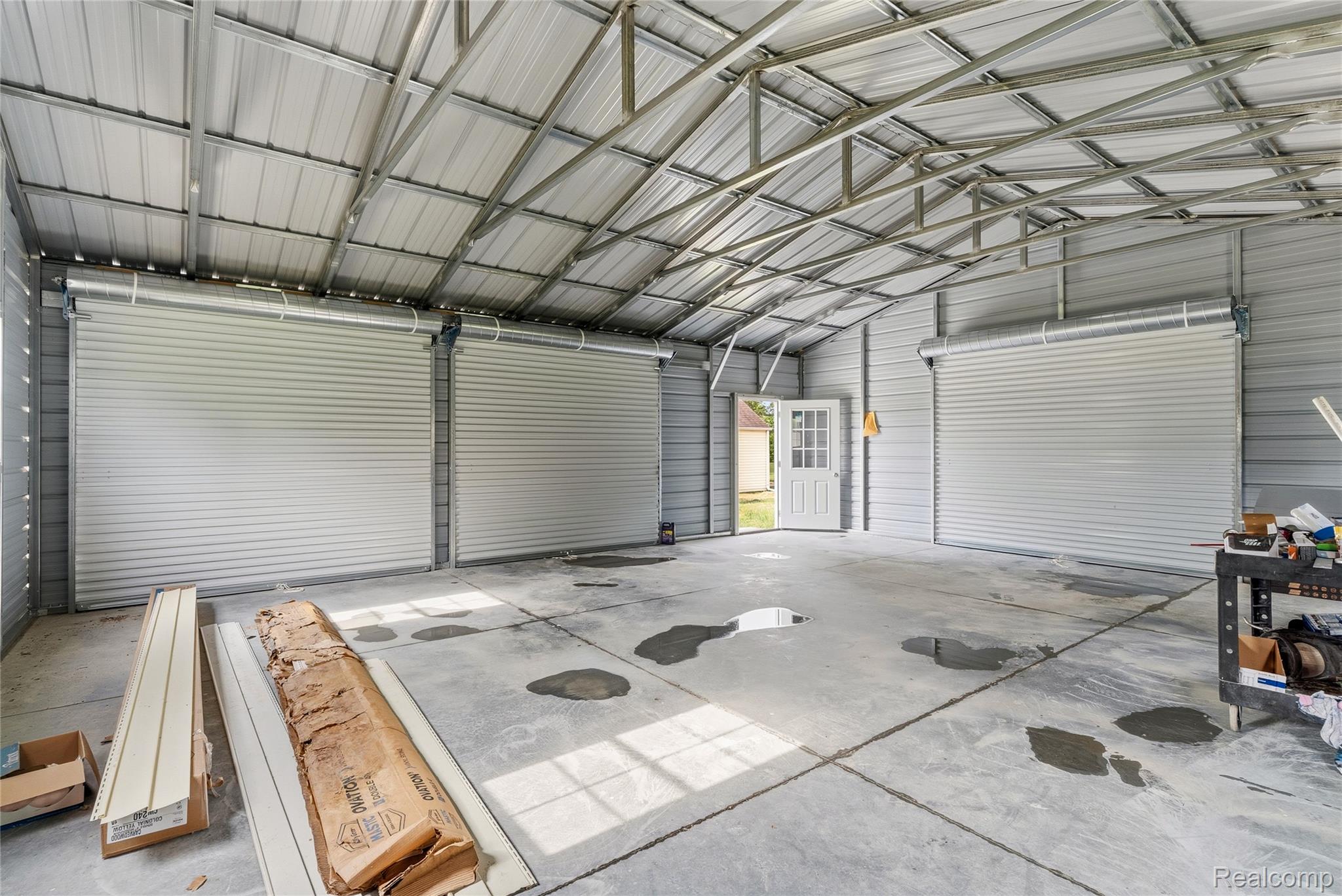 3241 East Frances Road Clio, MI 48420 - Photo 23 of 32 Spacious metal structure featuring an exposed truss roof system and concrete flooring
