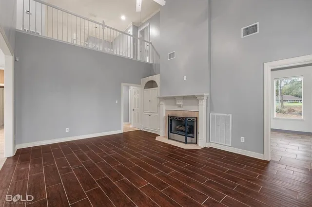 a view of empty room with wooden floor and fireplace