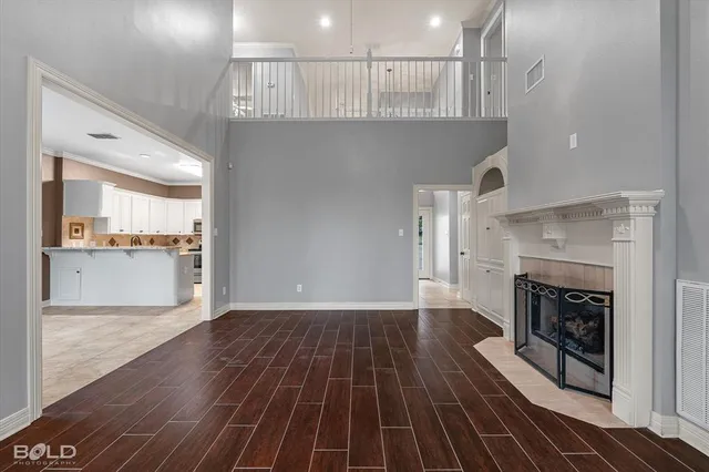 a view of a livingroom with wooden floor and a kitchen