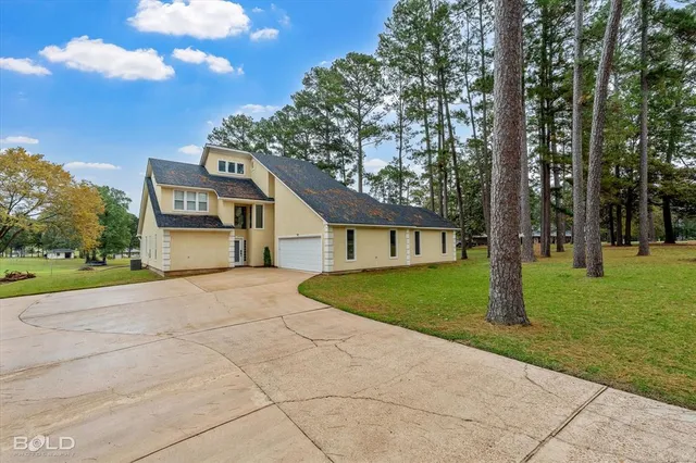 a front view of a house with a yard and trees